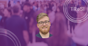 Rustam Rakhmanov and blurred background of conference. TReSI logo